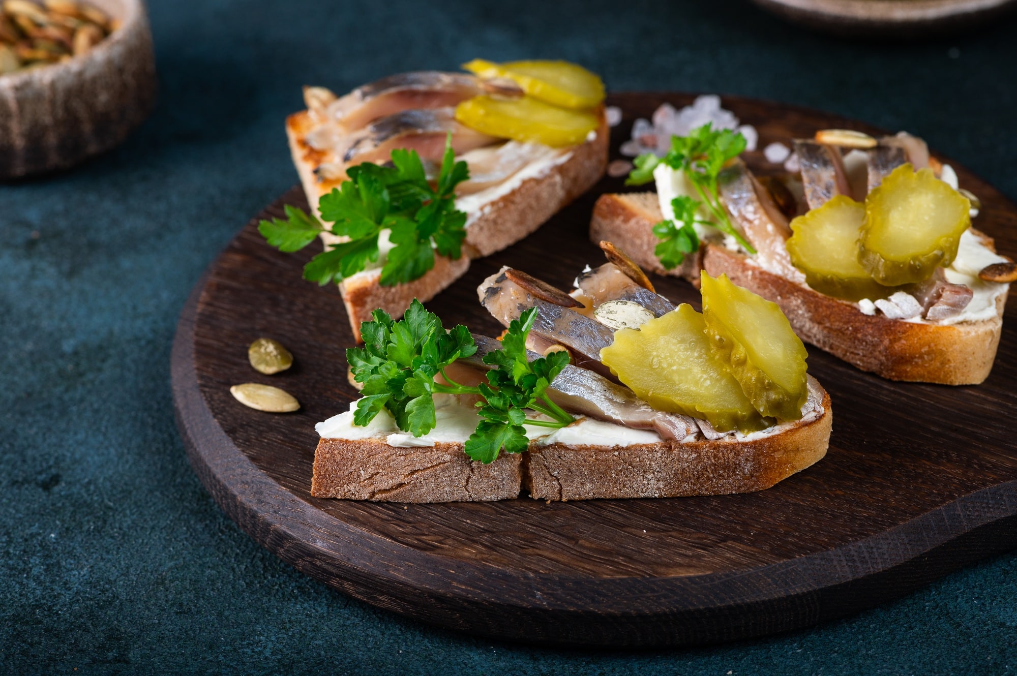 Toasts with bread, herring, pickled cucumber. Smorrebrod. Danish food. Sandwich with herring