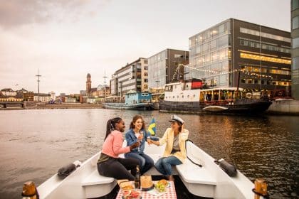 Young female friends having picnic on boat tour